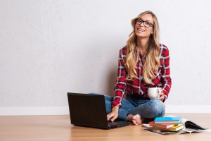 Young creative woman sitting in the floor with laptop.